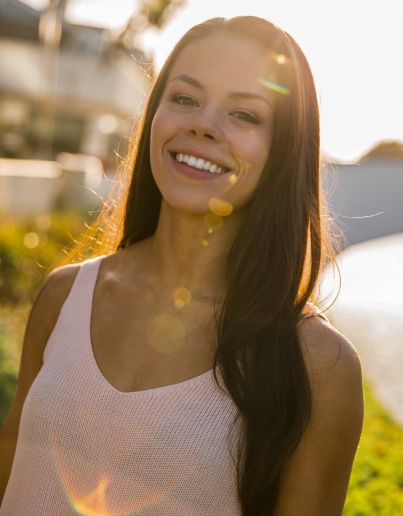 A headshot photo of Liv Smith standing outside in the sunlight.